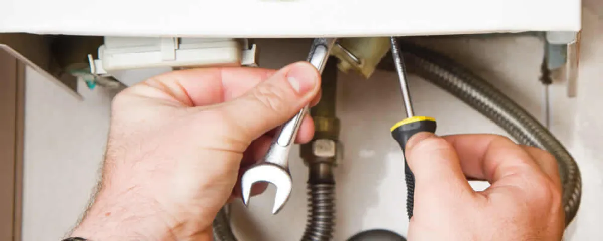 Boiler repair technician tightening pipe fittings and connections in Ogden, UT