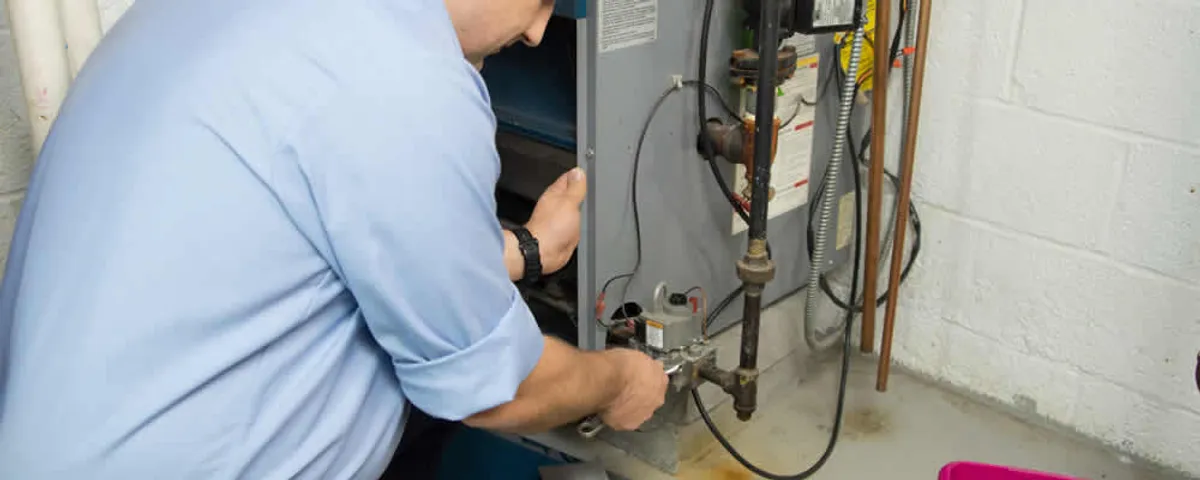 Furnace repair technician inspecting and servicing a home heating system in Ogden, UT