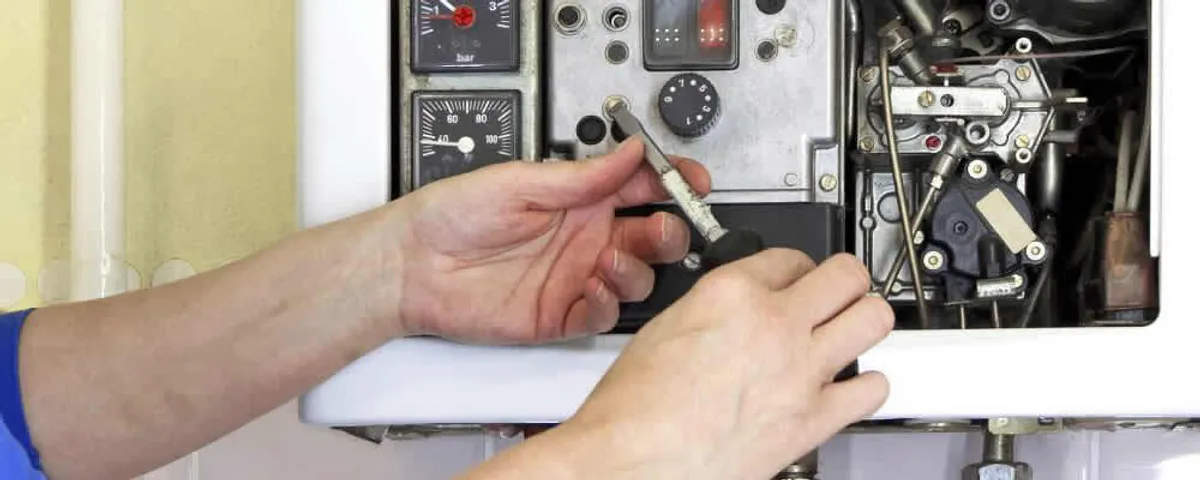 Heating repair technician adjusting boiler controls and components in Ogden, UT