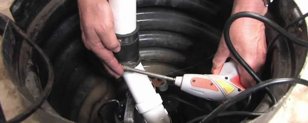 Sump pump installation technician connecting PVC discharge piping in Ogden, UT